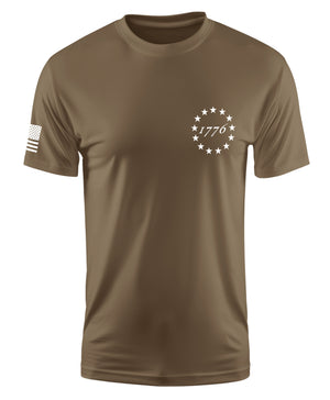 A short-sleeve crewneck t-shirt in olive drab brown, featuring a white circular star design with '1776' text on the left chest and a white American flag graphic on the right sleeve, shown against a plain white background.
