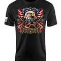 A black short-sleeve t-shirt with a detailed patriotic graphic on the chest featuring an eagle, crossed rifles, American flags, and the year 1776. A small black-and-white American flag is printed on the right sleeve.