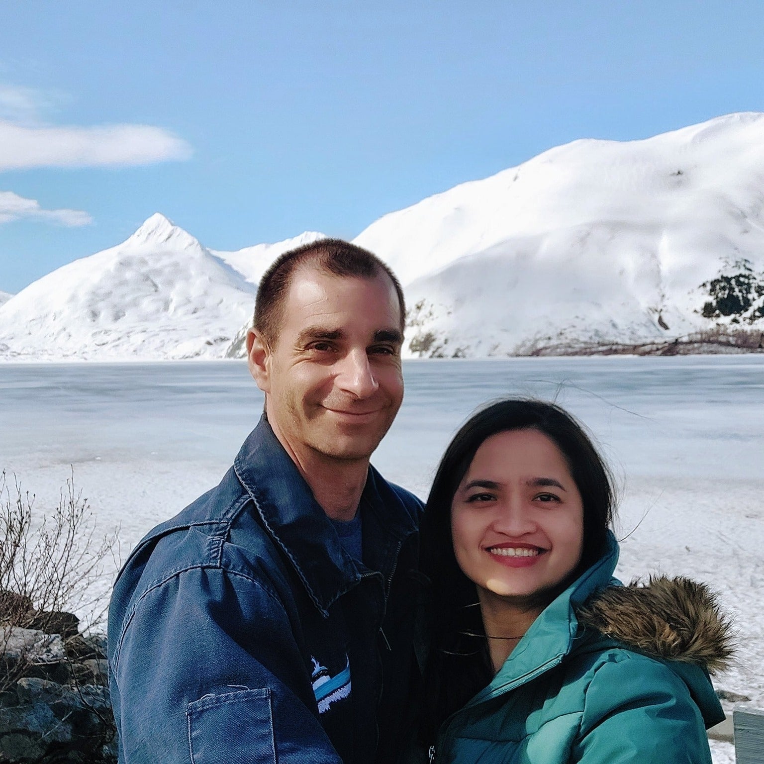 Justin and Jasmin standing in front of a snowy mountain landscape in Alaska