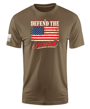 A brown short-sleeve crewneck t-shirt featuring a distressed graphic on the chest with the text 'DEFEND THE' above an American flag and 'second' in red script below. A small black-and-white flag graphic is visible on the right sleeve.